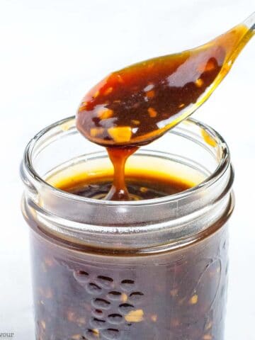 A spoonful of teriyaki sauce in a small Mason jar.