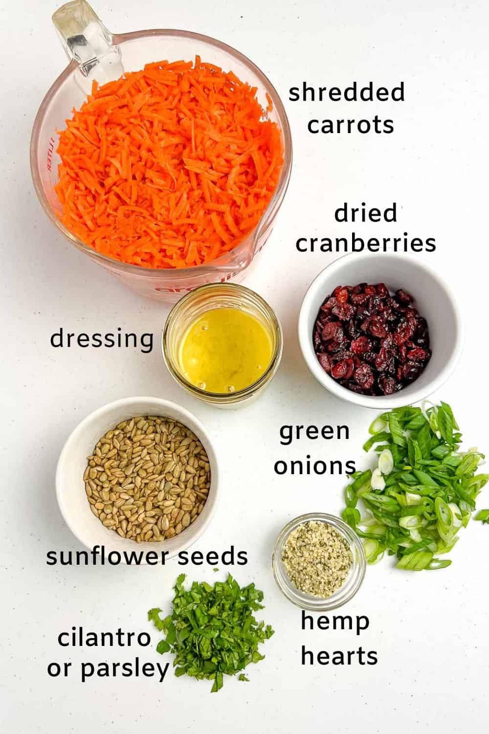 Labelled ingredients for carrot salad with honey-mustard dressing.
