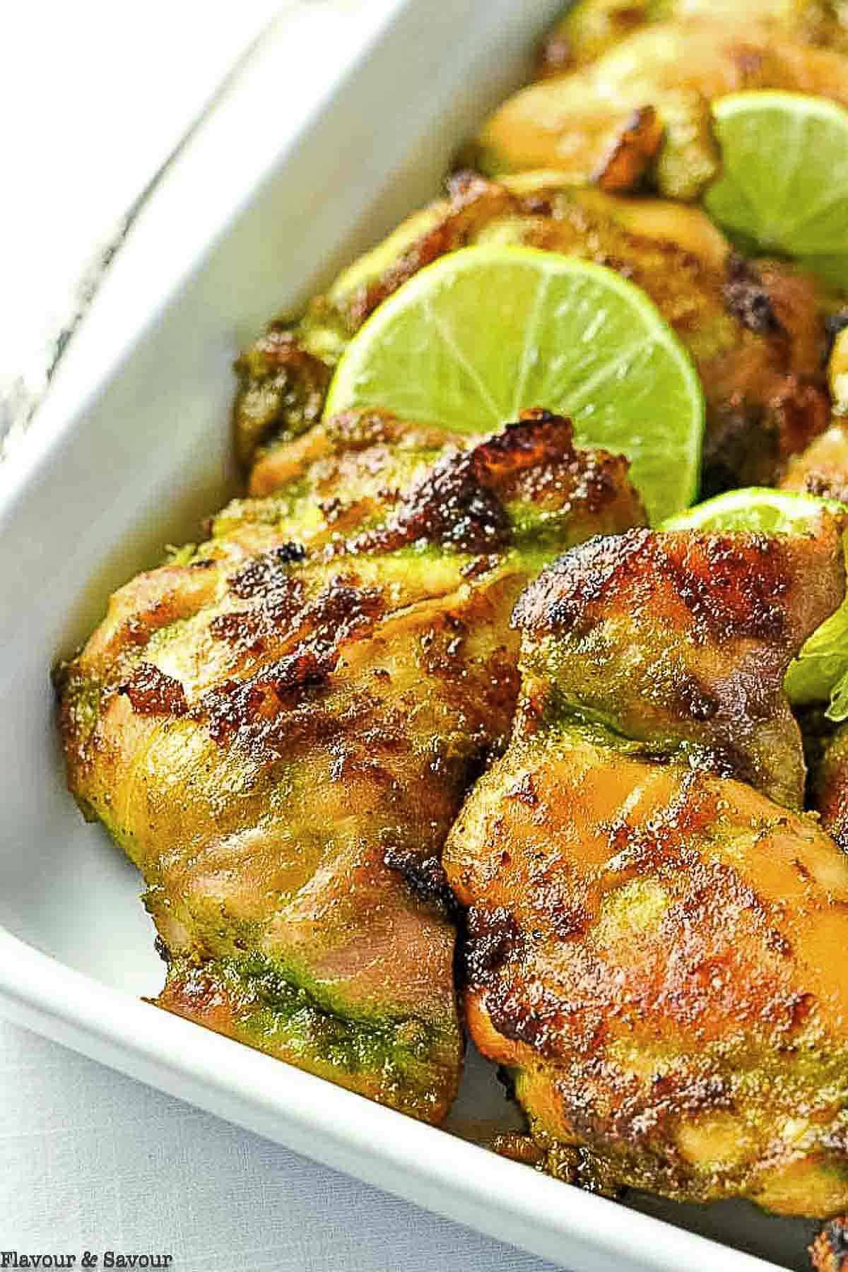 Close up view of Thai baked chicken with lime slices.
