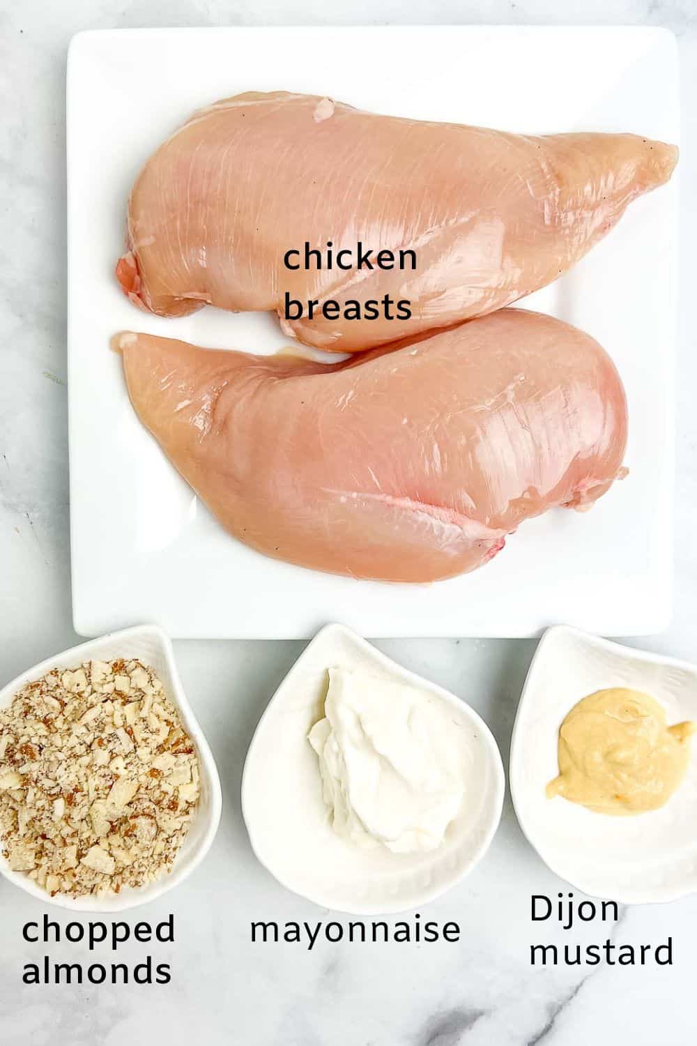 Ingredients for almond-crusted chicken: chicken breasts, chopped almonds, mayonnaise and Dijon mustard.