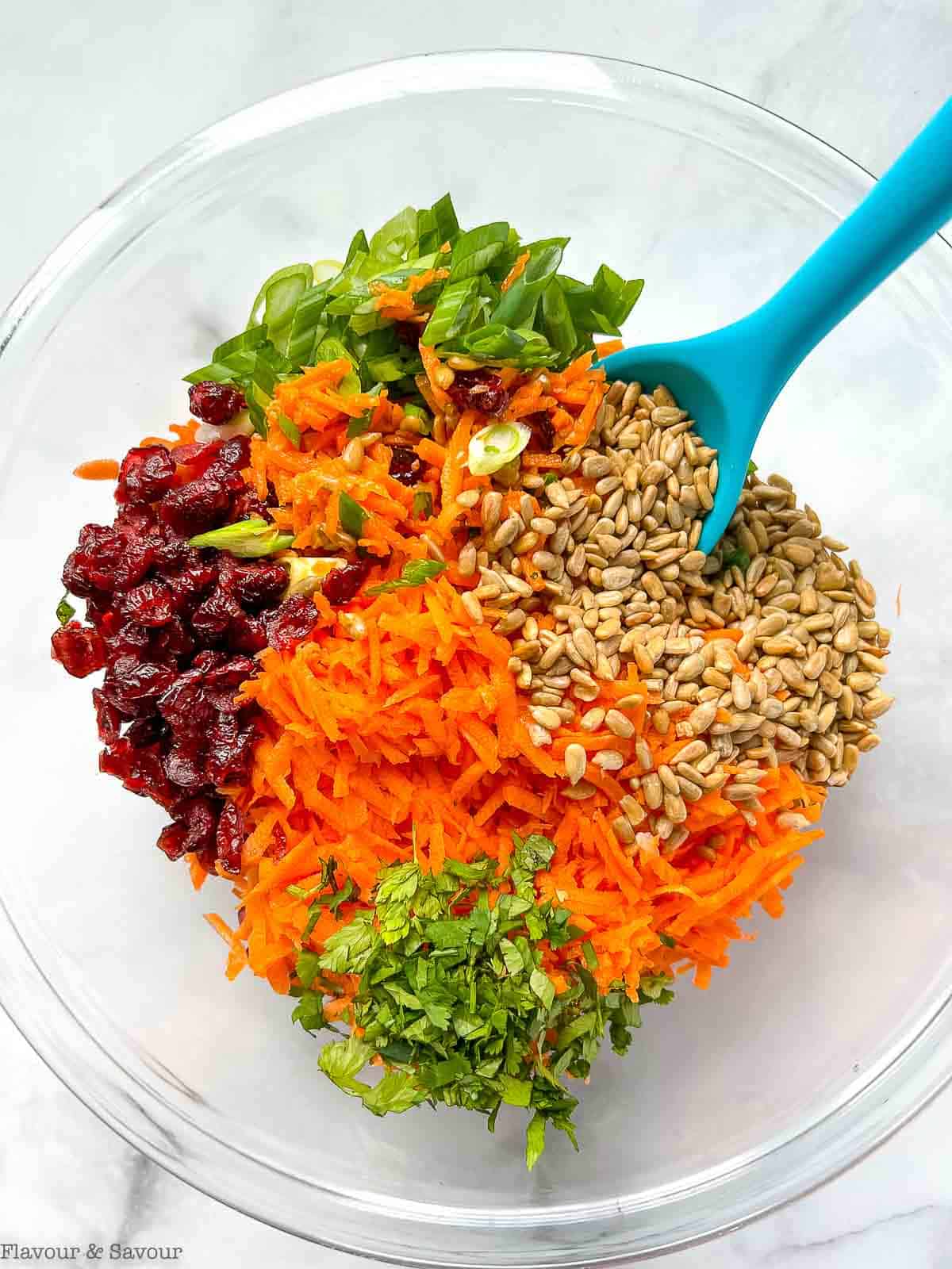 Ingredients for carrot salad in a glass bowl.