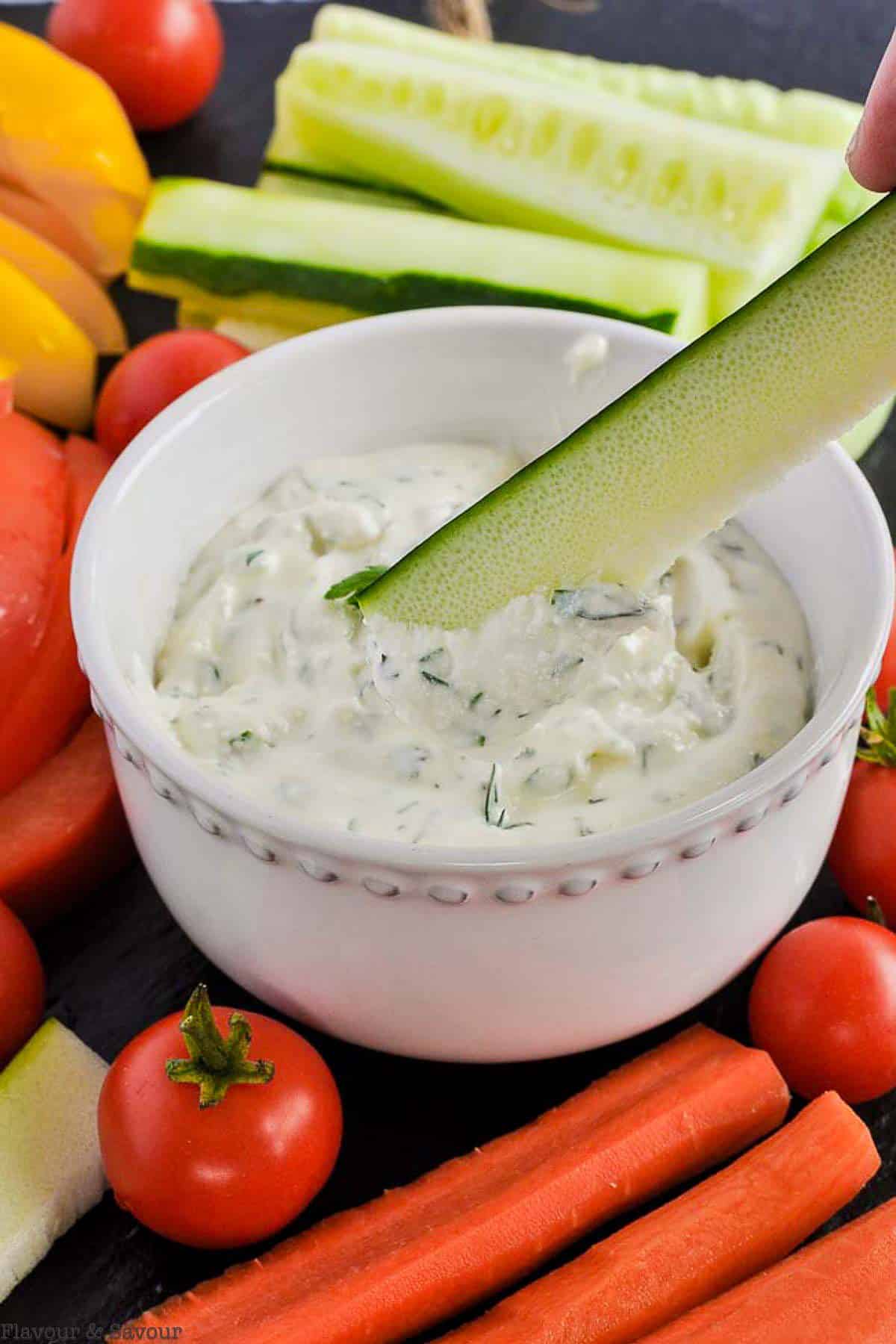 A zucchini stick dipped in herbed lemon feta dip.