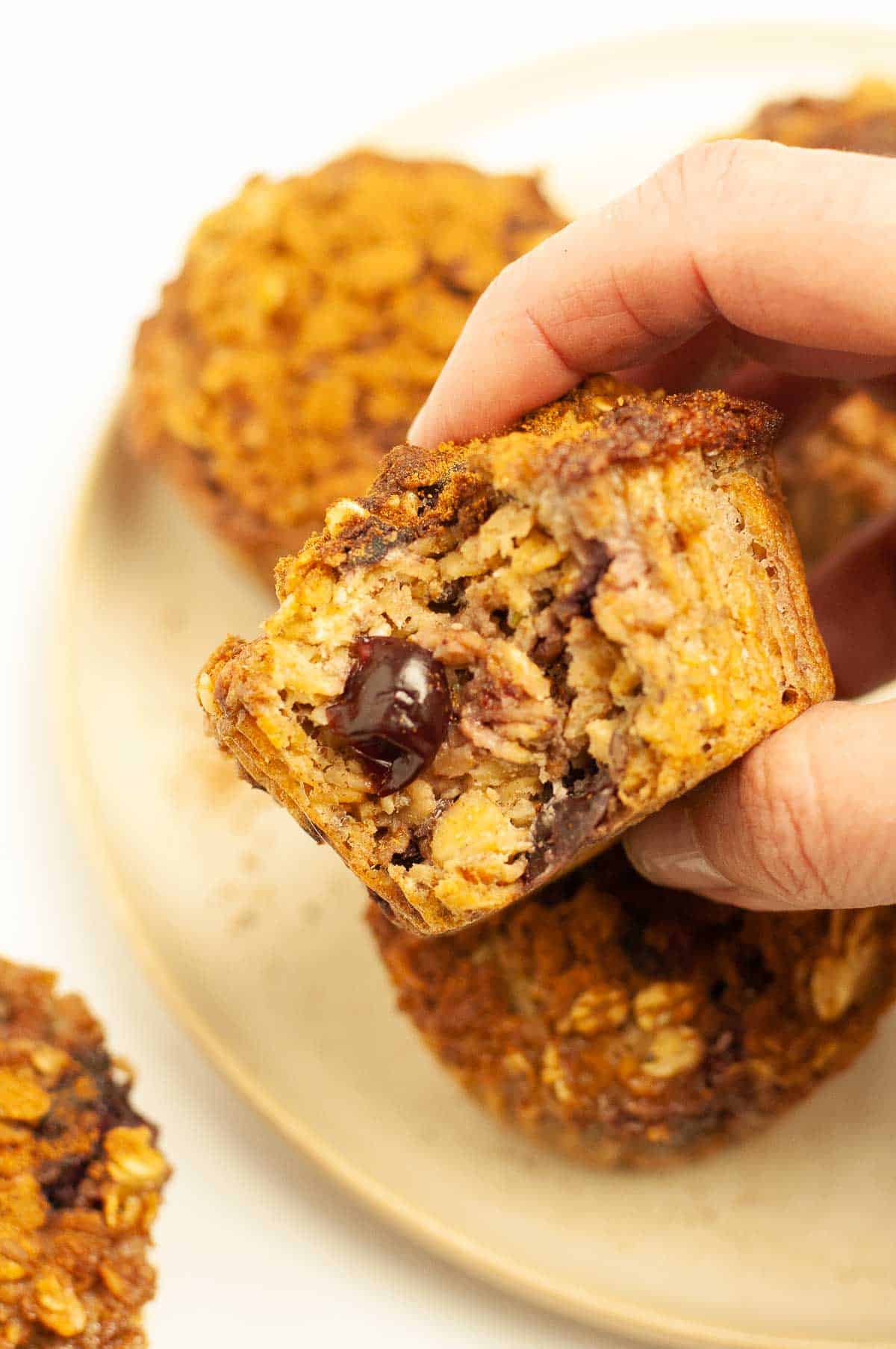 A hand holding a cherry baked oatmeal cup.