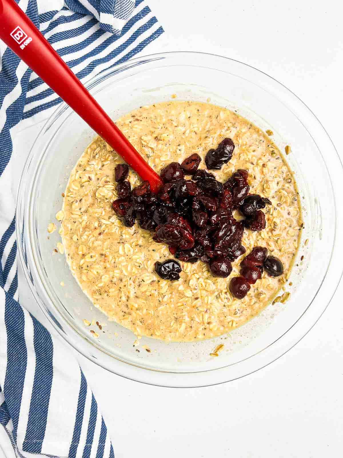 Adding chopped cherries to baked oatmeal batter.