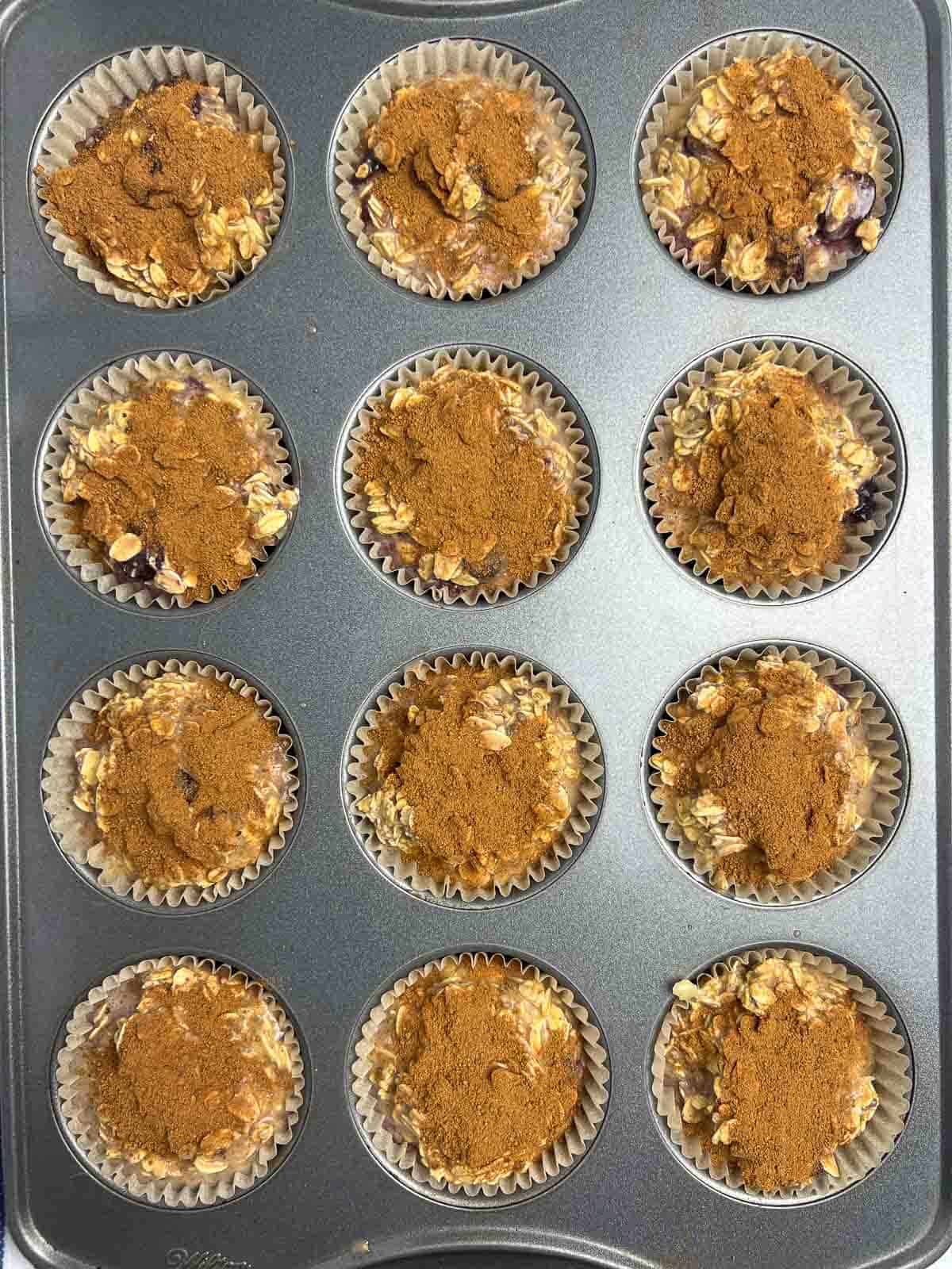 Cherry baked oatmeal in a muffin tin ready to bake.