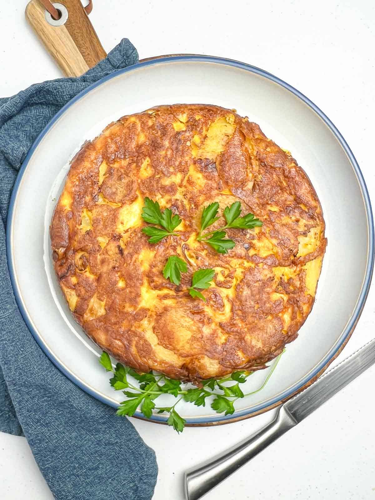 Baked Spanish tortilla inverted onto a serving plate.