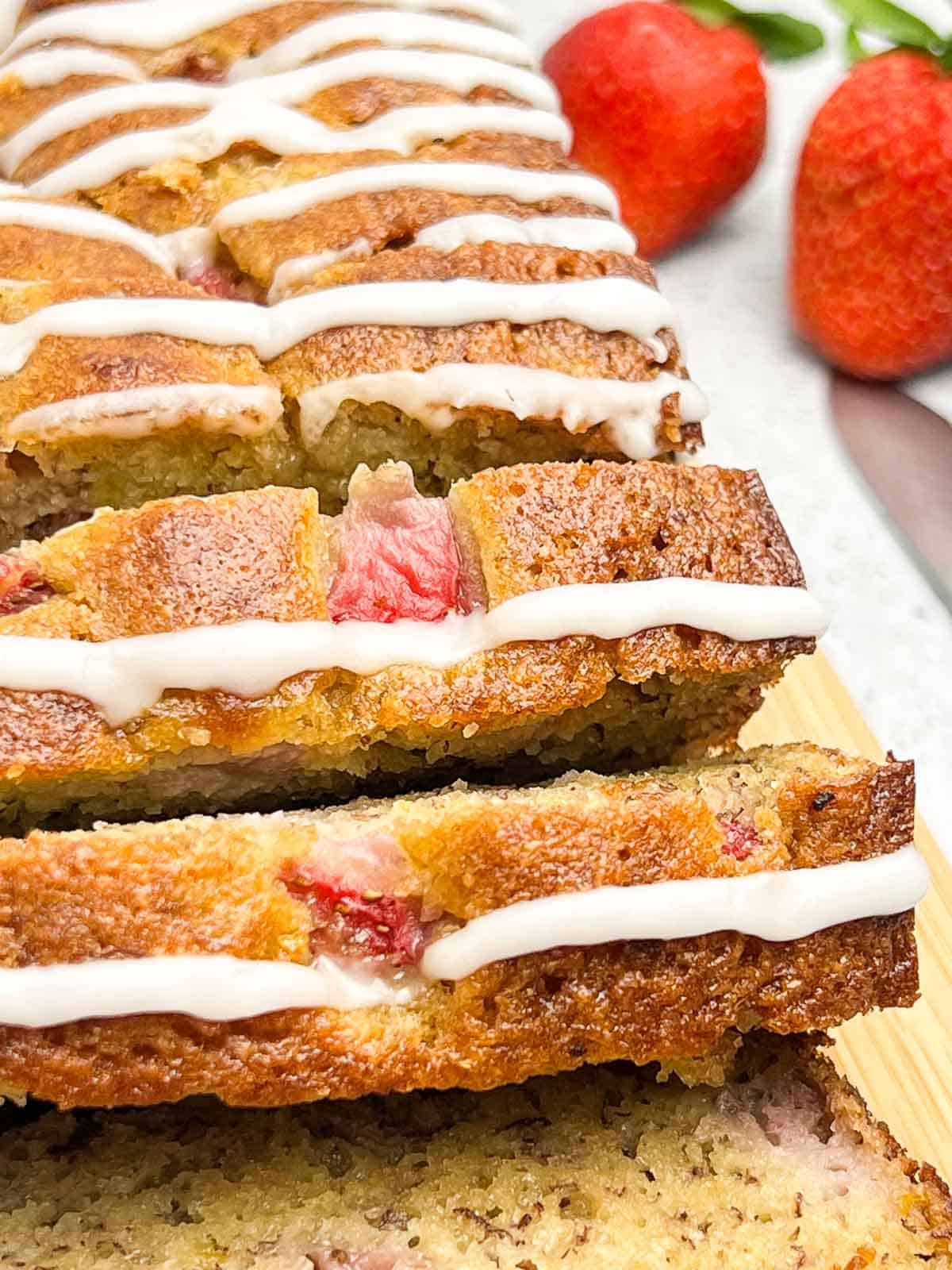 Close up view of slices of almond flour strawberry banana bread with lemon glaze.