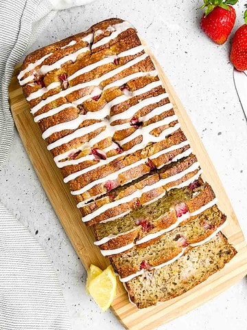 Overhead view of a sliced loaf of almond flour banana bread with strawberries.