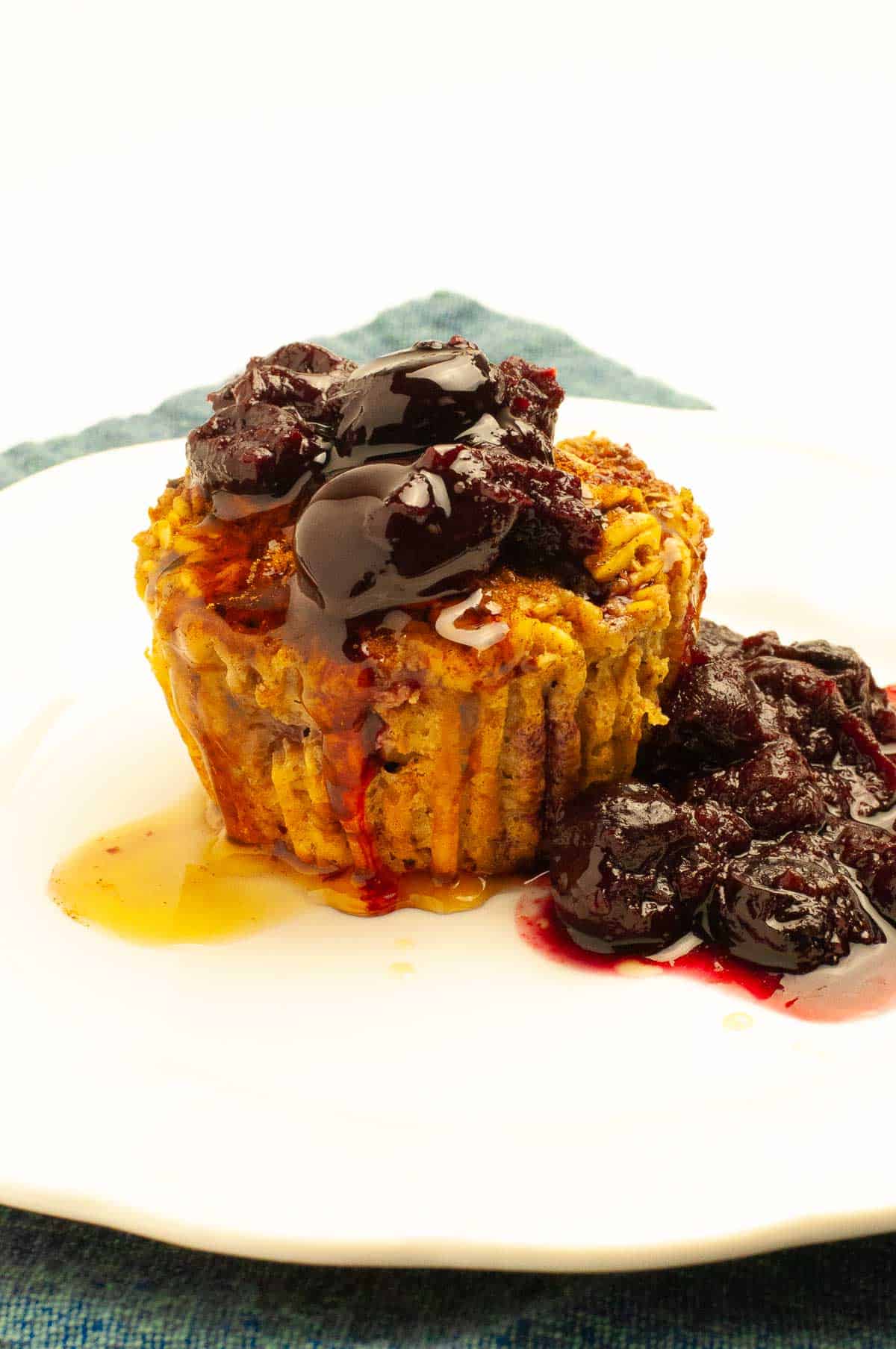 A cherry baked oatmeal cup with cherry sauce and a drizzle of maple syrup.