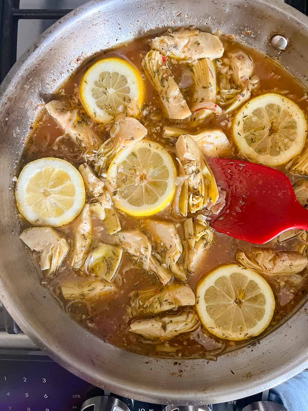 Add garlic, shallots, lemon broth, wine and thyme to the skillet to make the sauce for lemon artichoke chicken.