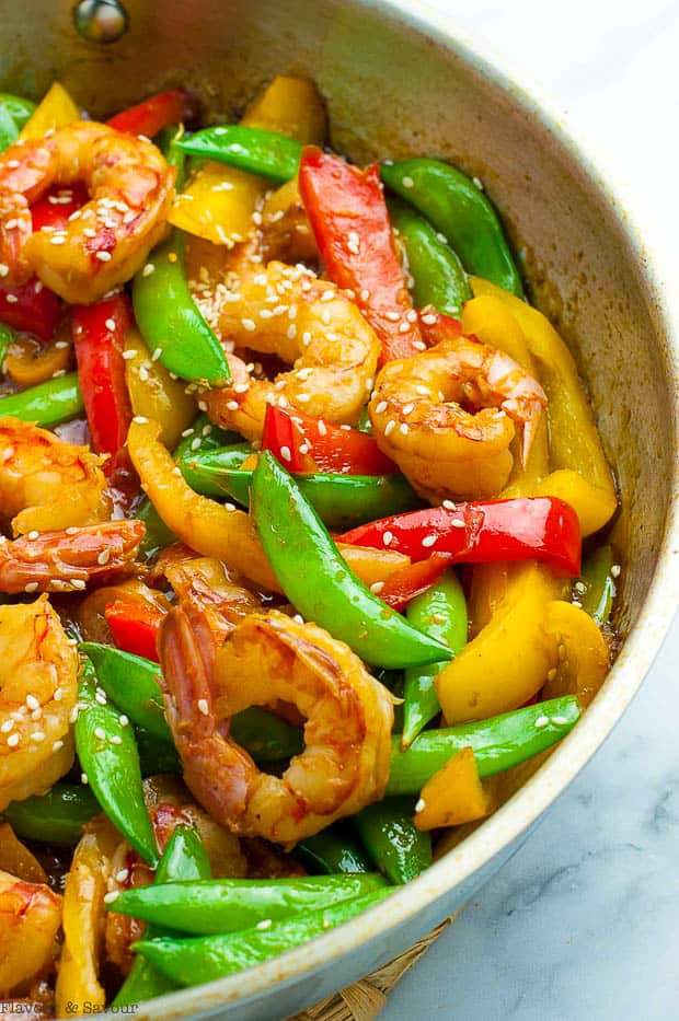 Lemon garlic shrimp with snow peas and peppers in a skillet.