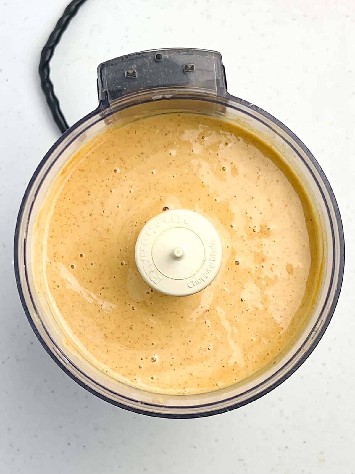 Spicy peanut sauce for chicken satay in a food processor bowl.