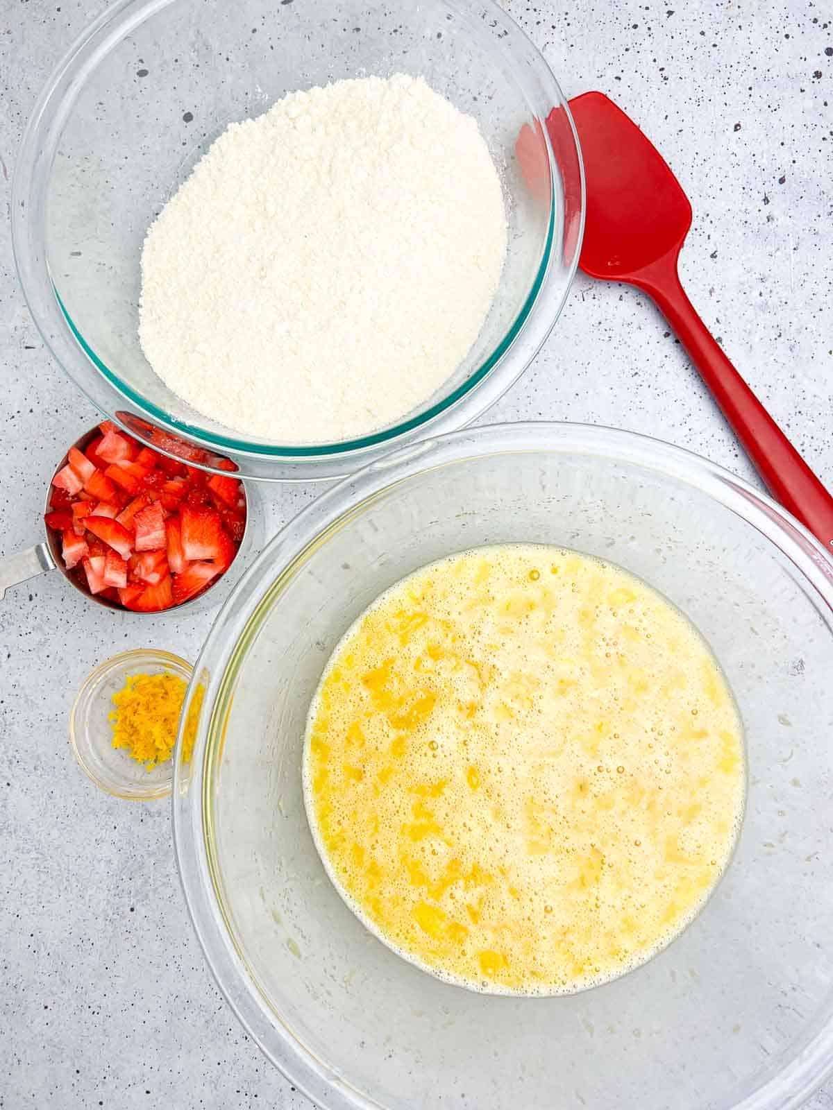 Preparing strawberry banana bread with dry ingredients in one bowl and wet ingredients in another.