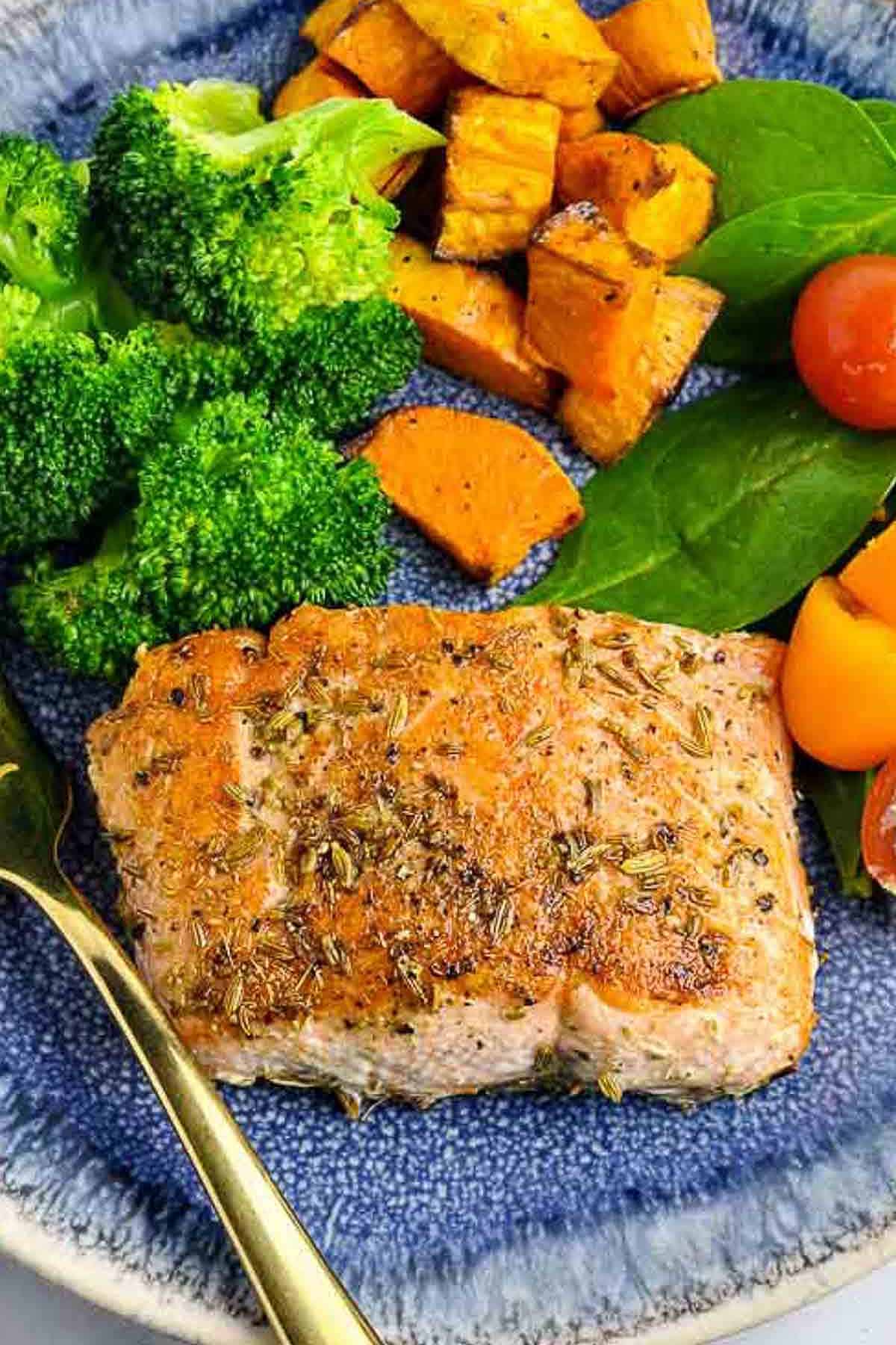 Close up view of a salmon fillet with fennel seed coating.