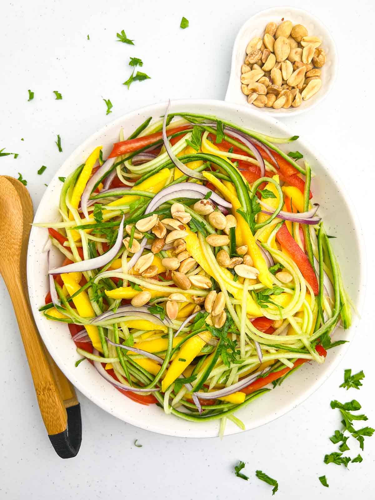 Overhead view of a bowl of Asian Mango Salad with peanuts.