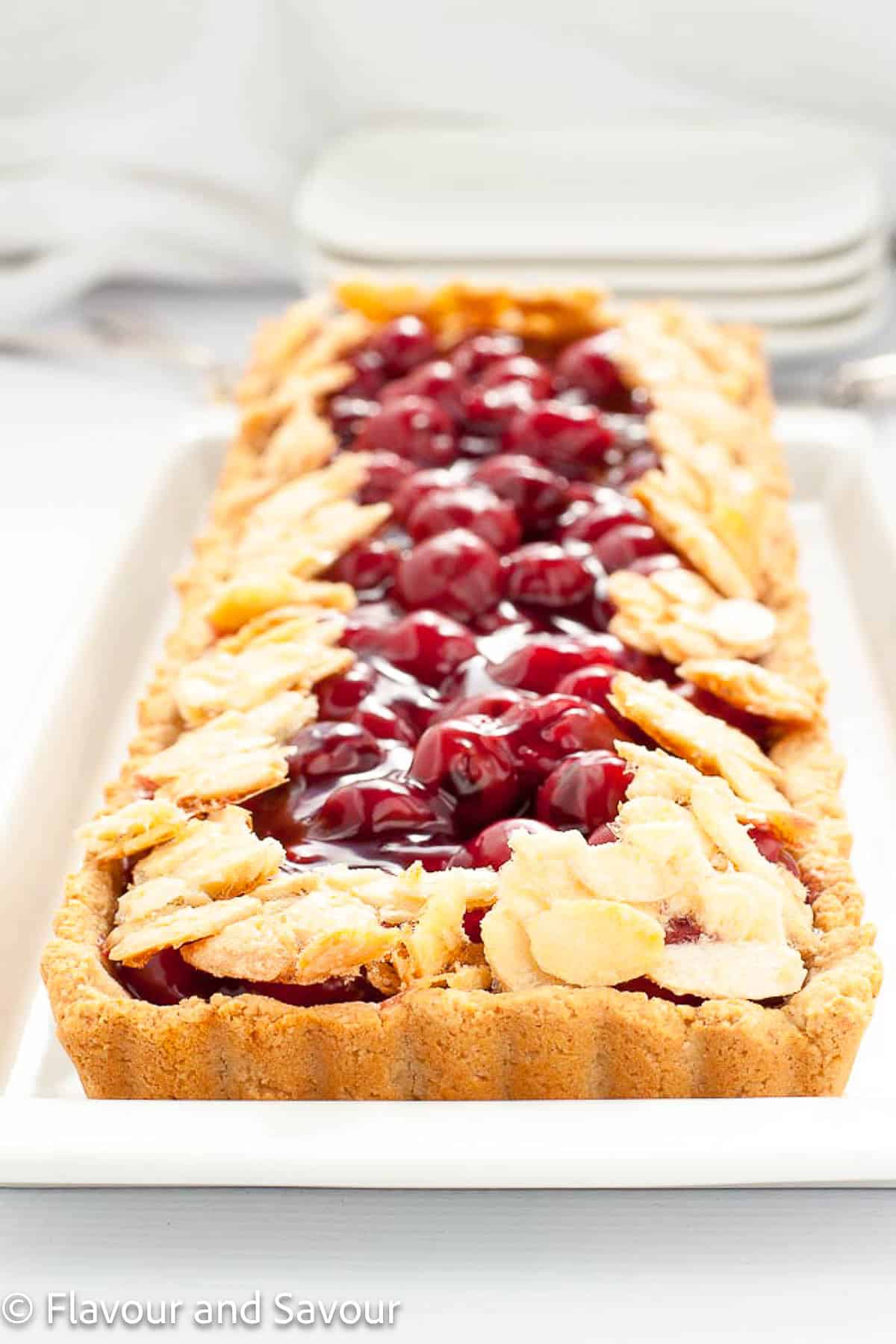 Gluten-free sour cherry almond tart baked in an oblong tart pan.