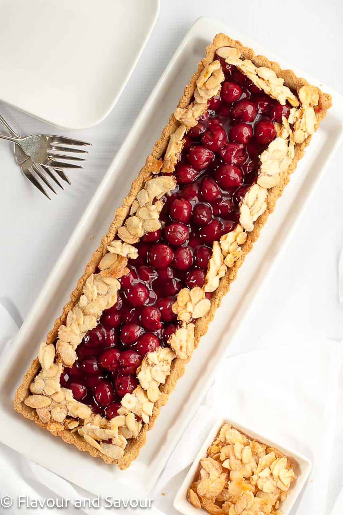 Overhead view of a cherry almond tart baked in a rectangular tart pan.