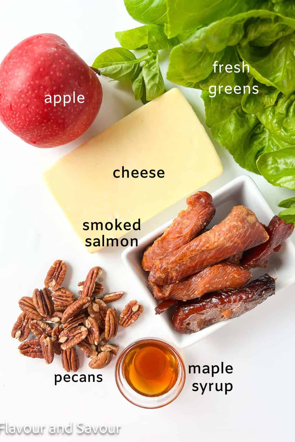 Ingredients for smoked salmon salad:  fresh greens, apple, cheese, smoked salmon, pecans, and maple syrup.