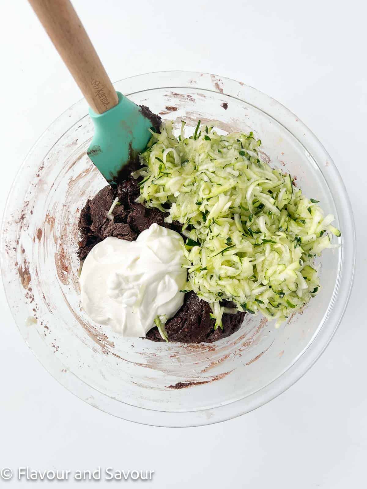 Adding zucchini and yogurt to muffin batter.