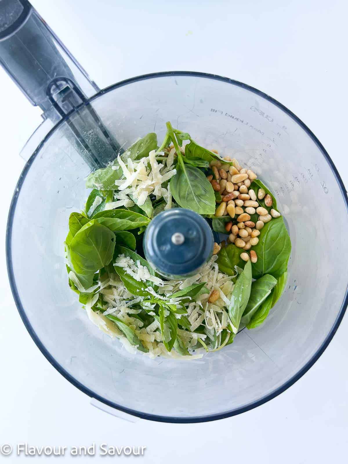 Pesto ingredients in a food processor.