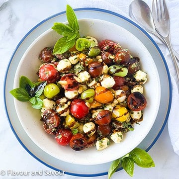 Pesto caprese salad with cherry tomatoes and balsamic glaze.