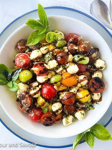 Pesto caprese salad with cherry tomatoes and balsamic glaze.