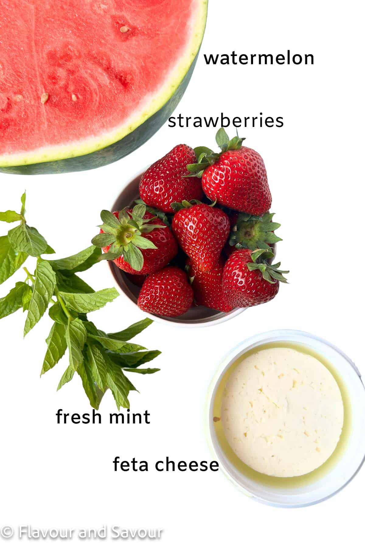 Ingredients for strawberry watermelon salad: watermelon, strawberries, feta cheese and mint leaves.