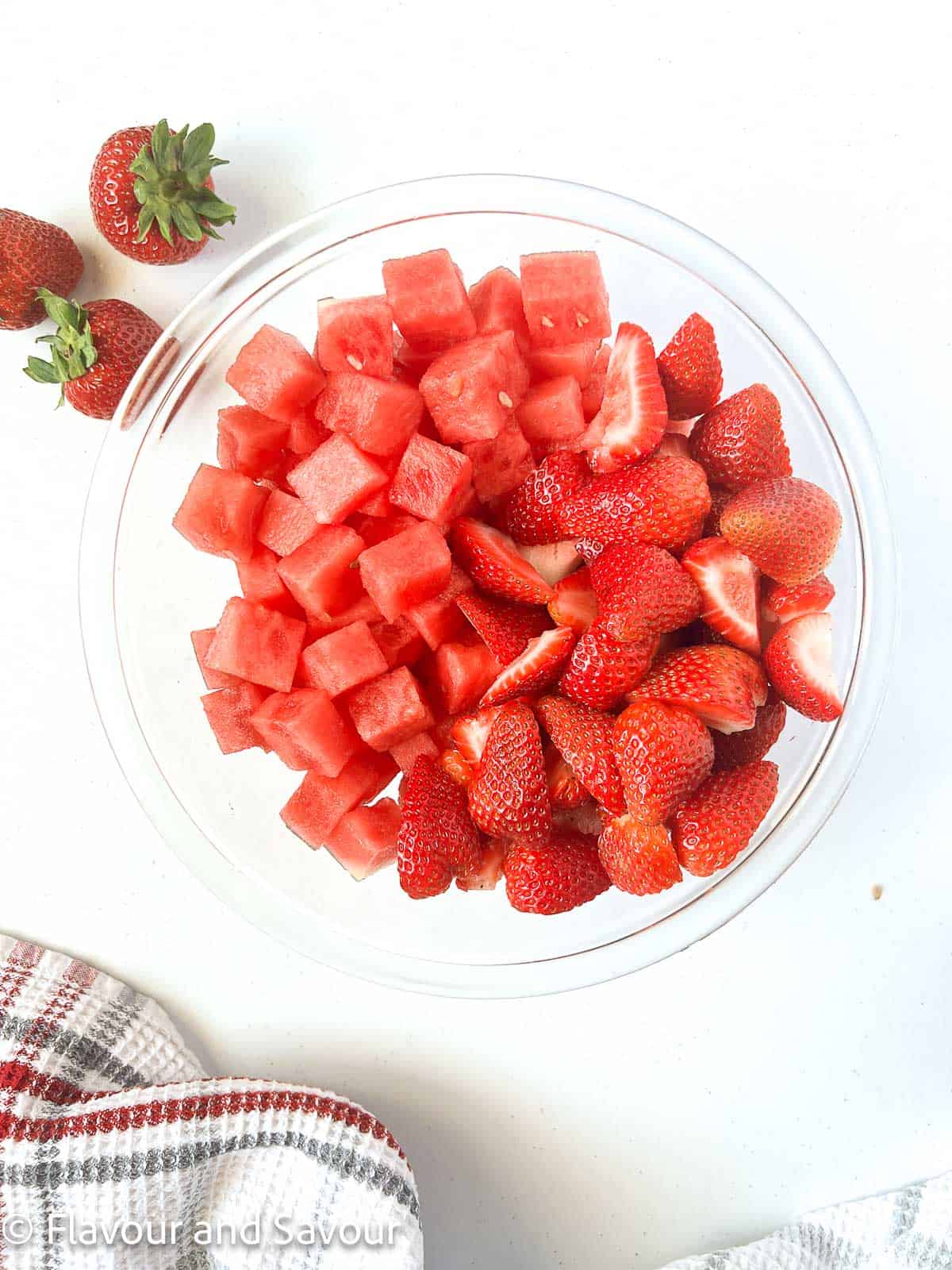 A bowl of cubed watermelon and sliced strawberries.
