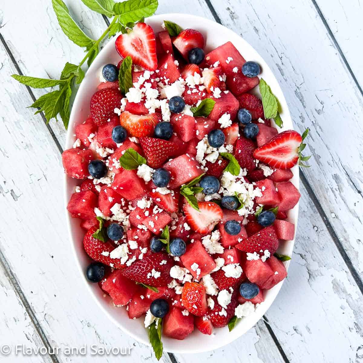 A bowl of strawberry watermelon salad with blueberries.