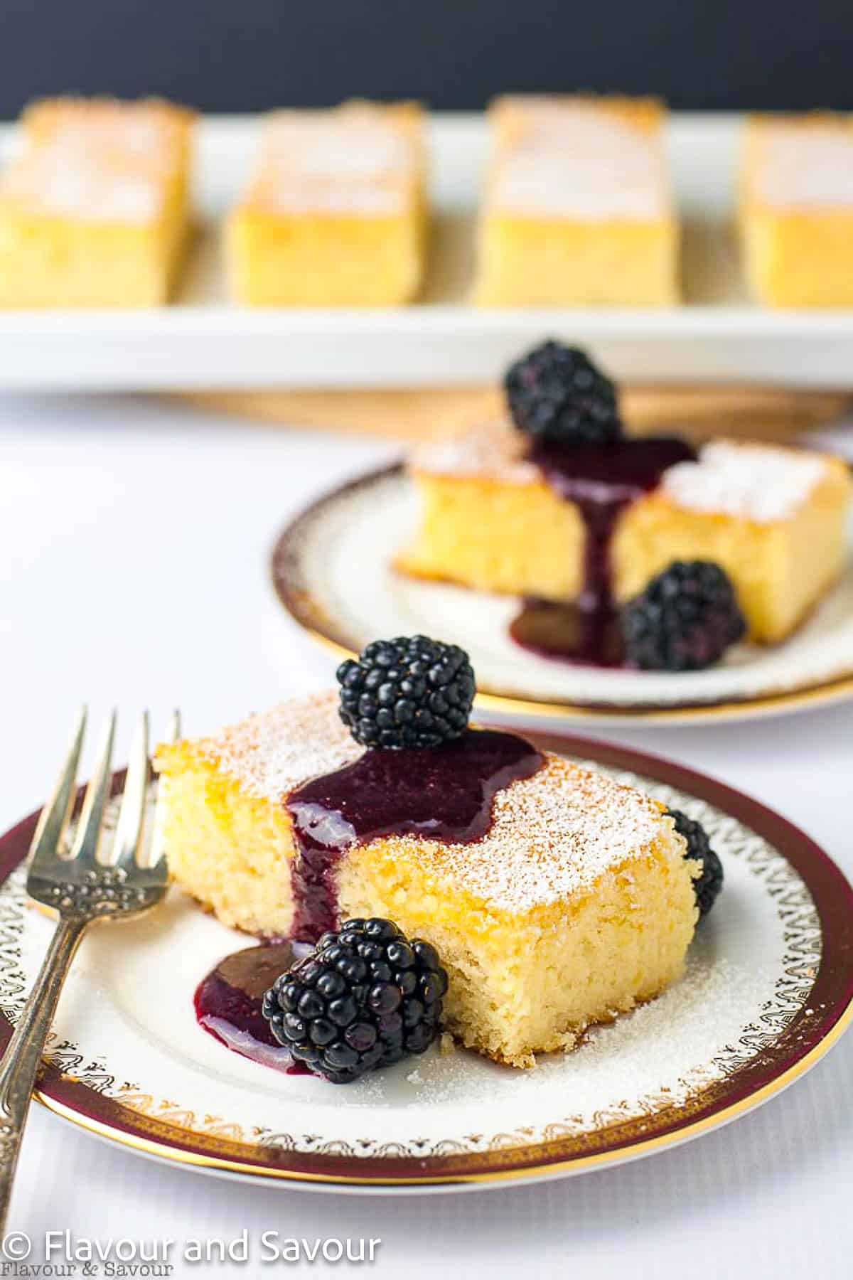 Flourless Lemon Almond Ricotta Cake with Blackberry Coulis on a plate with a fork.
