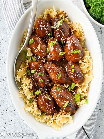 Slow Cooker Sticky Chicken Thighs cooked in a crock pot and served over noodles.