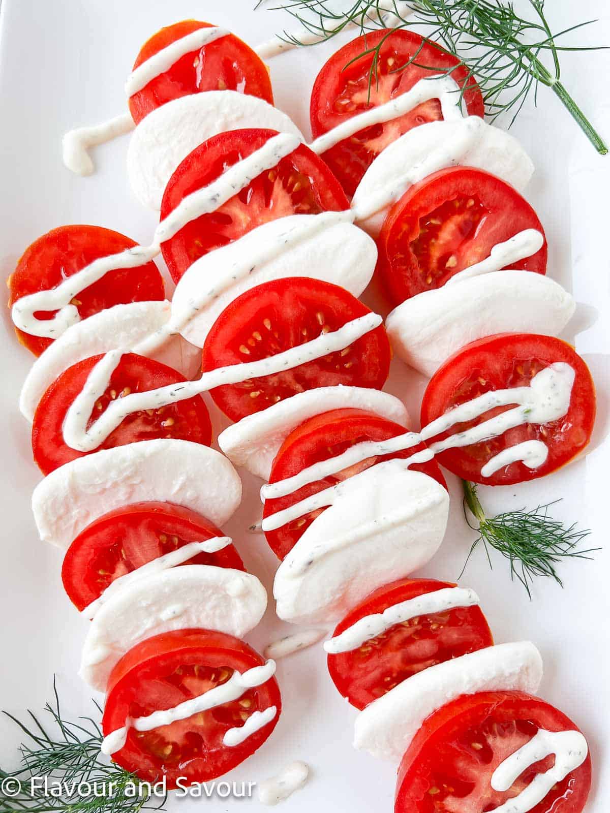 Tomato slices alternating with fresh mozzarella slices (bocconcini medallions) drizzled with dill dressing.