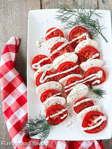 Dill Caprese Salad on a platter with fresh sprigs of dill weed.