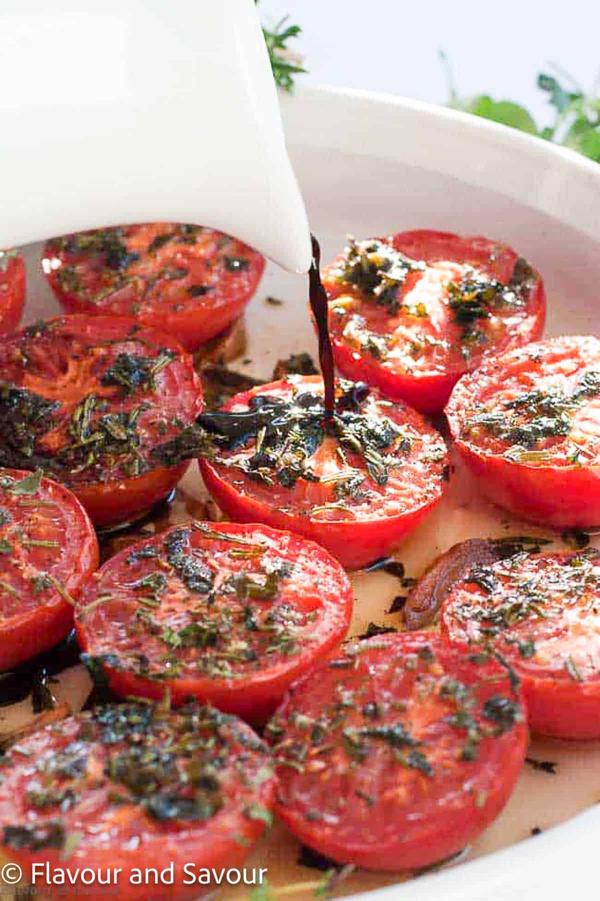 Drizzling balsamic vinegar on broiled tomatoes with herbs and garlic.
