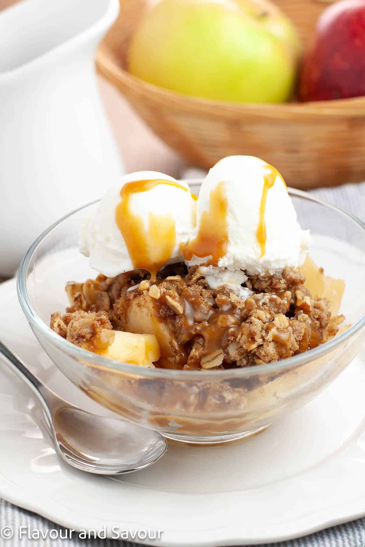 A bowl of gluten-free apple pecan crisp with salted caramel sauce.