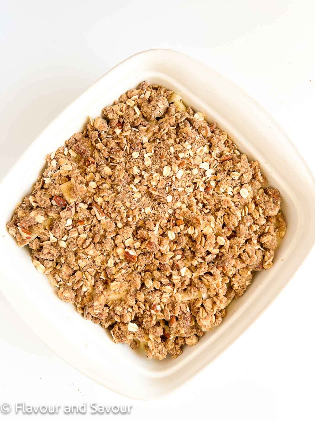 Apple pecan crisp in an 8-inch square baking dish ready to bake.