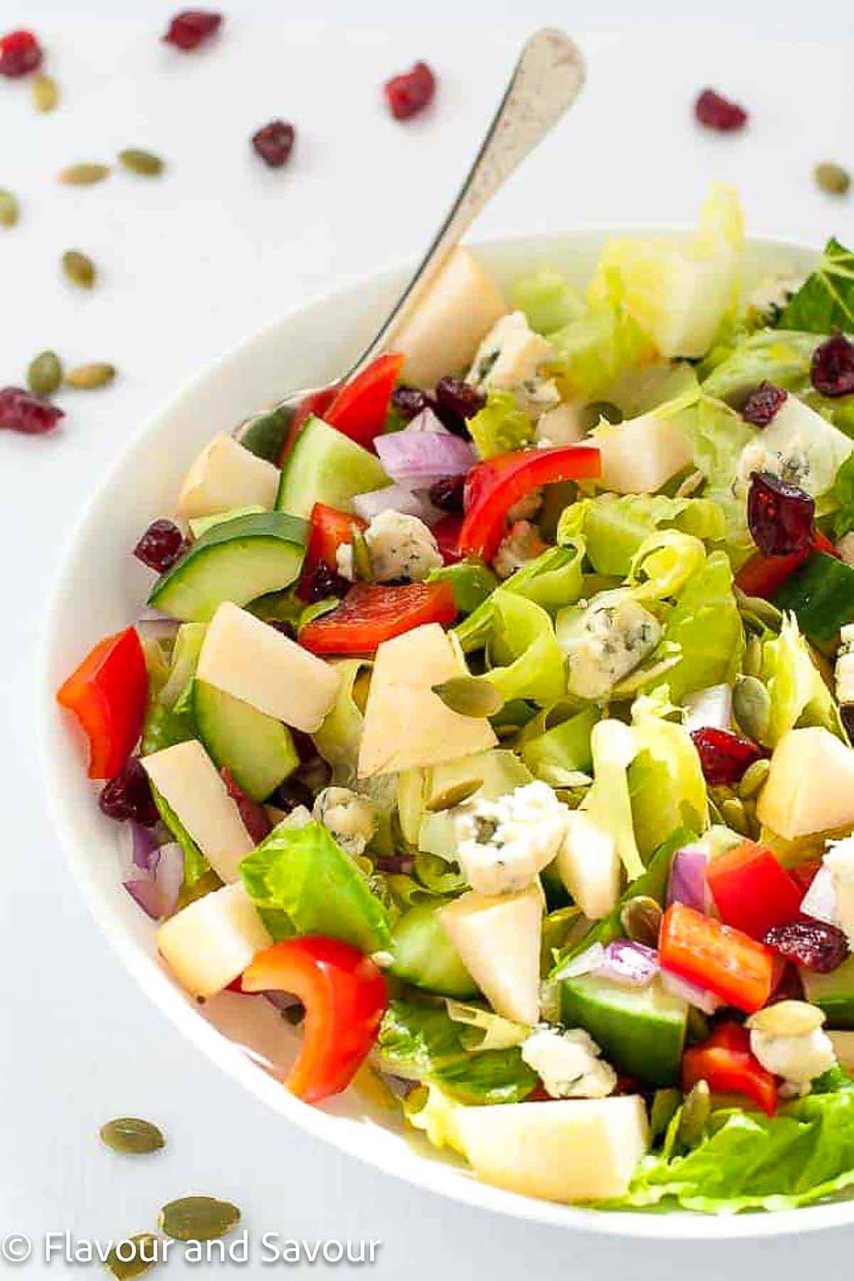 Closeup view of a bowl of chopped salad made with Asian pears, blue cheese and crunchy vegetables.