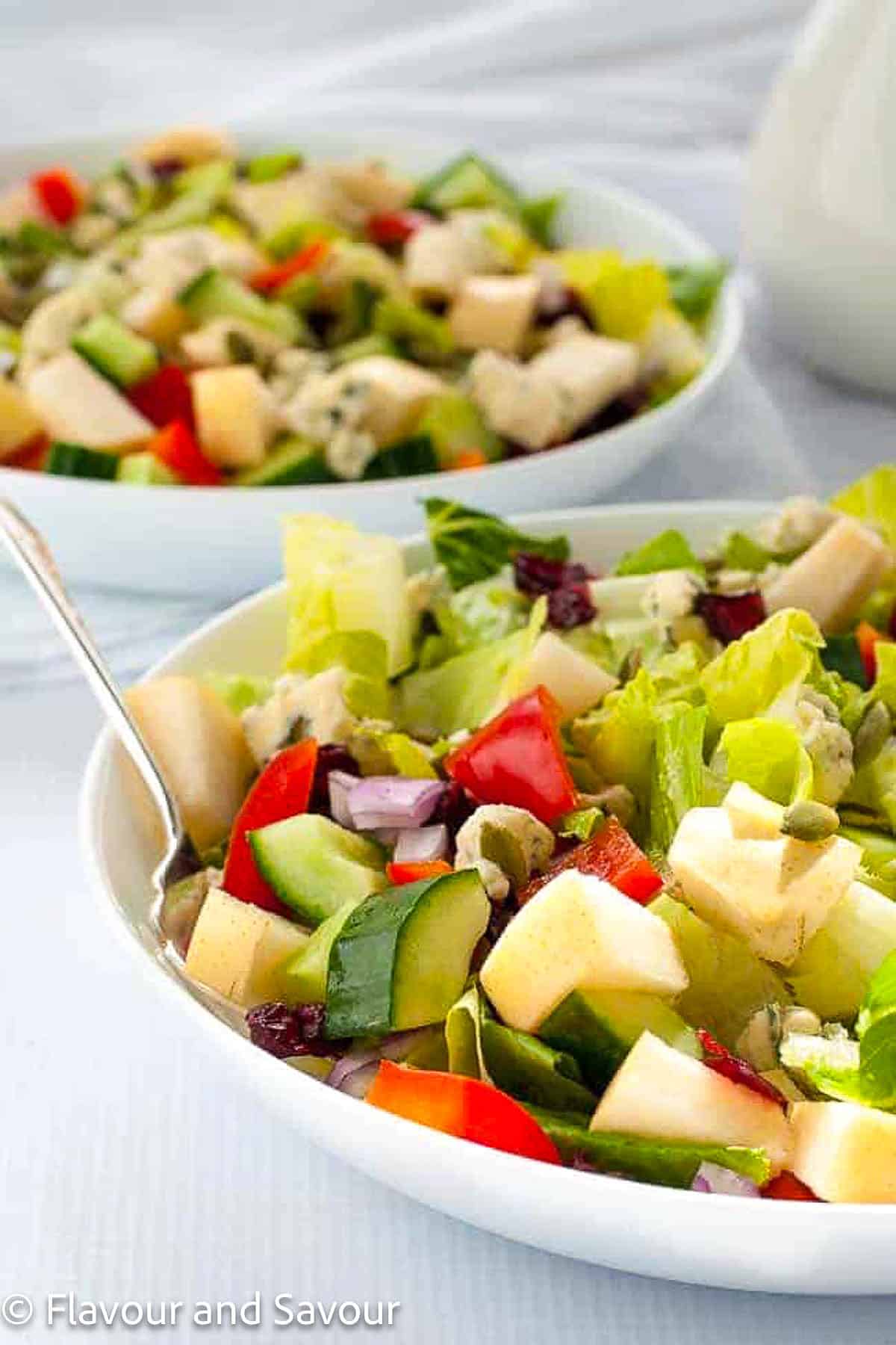 Two shallow white bowls filled with Asian pear (apple pear) chopped salad.