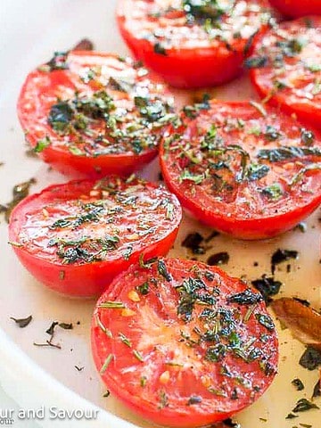 A plate of broiled Italian tomatoes square image.