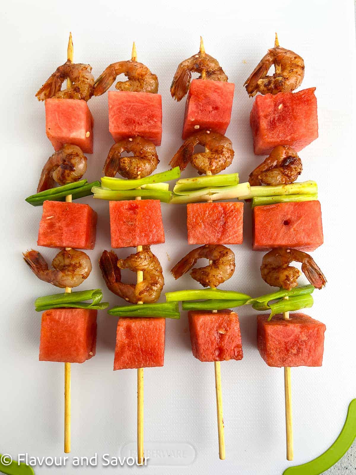 Spot prawn watermelon kabobs on wooden skewers ready to grill.