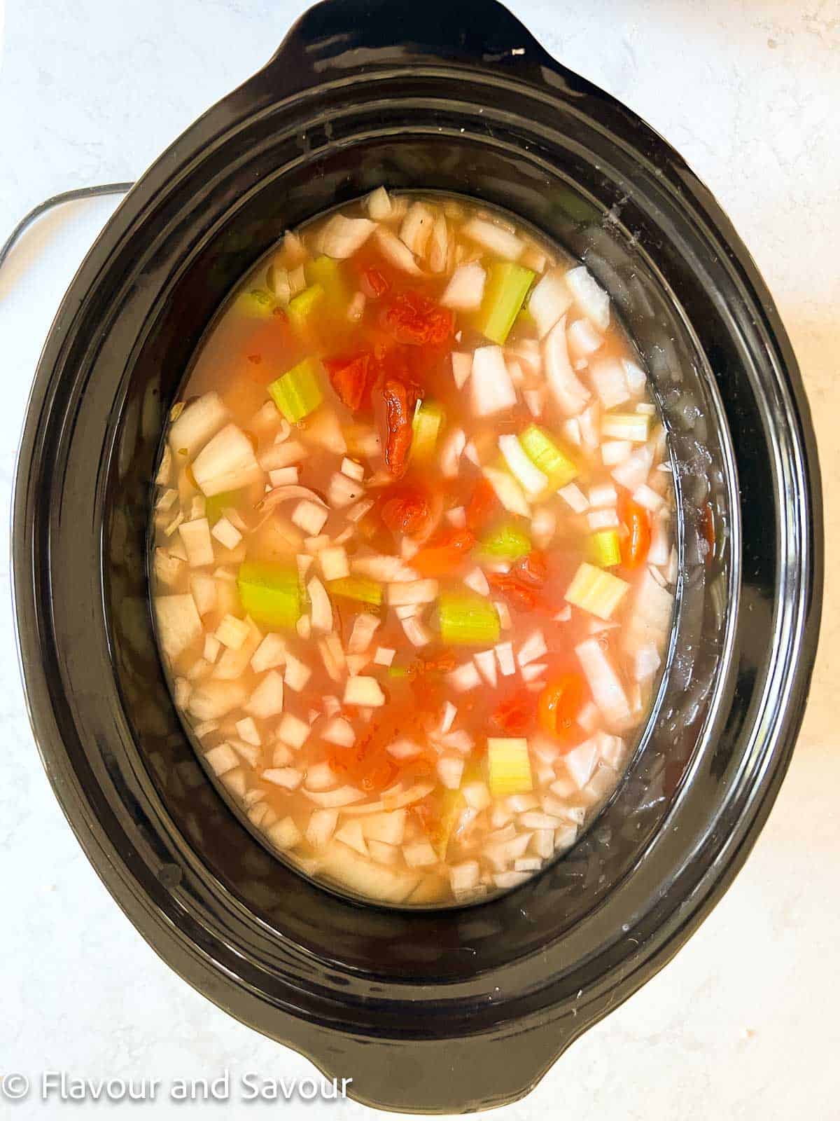 Lentil and sausage stew in a slow cooker, ready to cook.