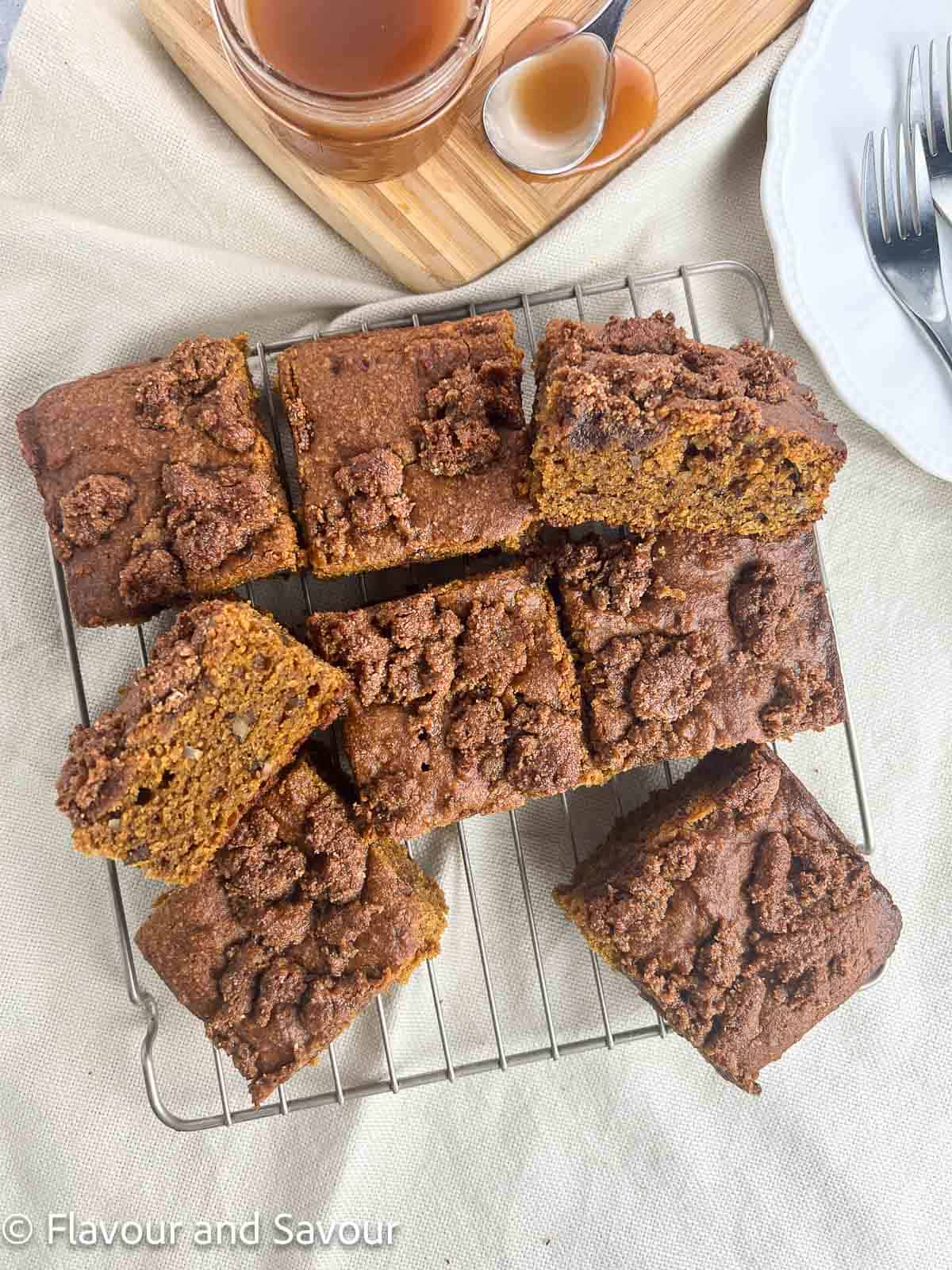 Overhead view of sliced pumpkin pecan coffee cake with a jar of caramel sauce in the background.