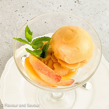 Closeup overhead view of peach ginger sorbet with fresh peach slices.