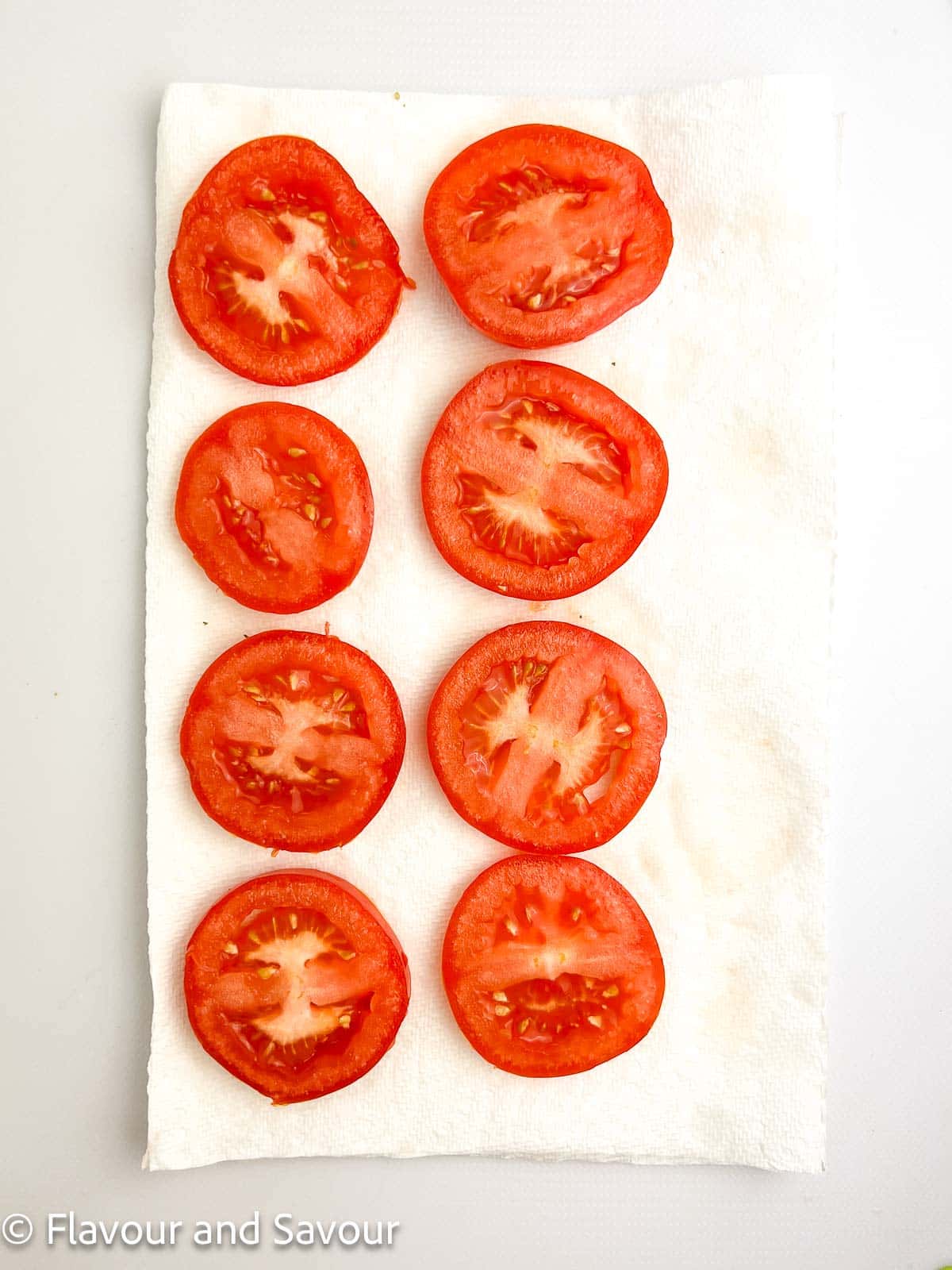 Tomato slices on a paper towel.