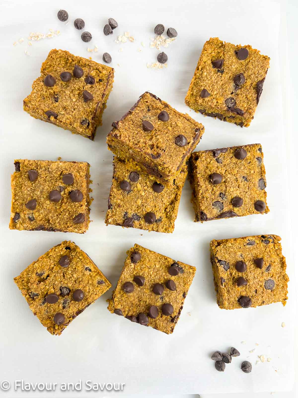 Overhead view of pumpkin chocolate chip oat bars with chocolate chips scattered around.