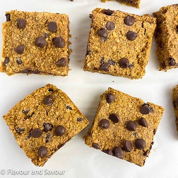 Square image of four pumpkin oat squares with chocolate chips.
