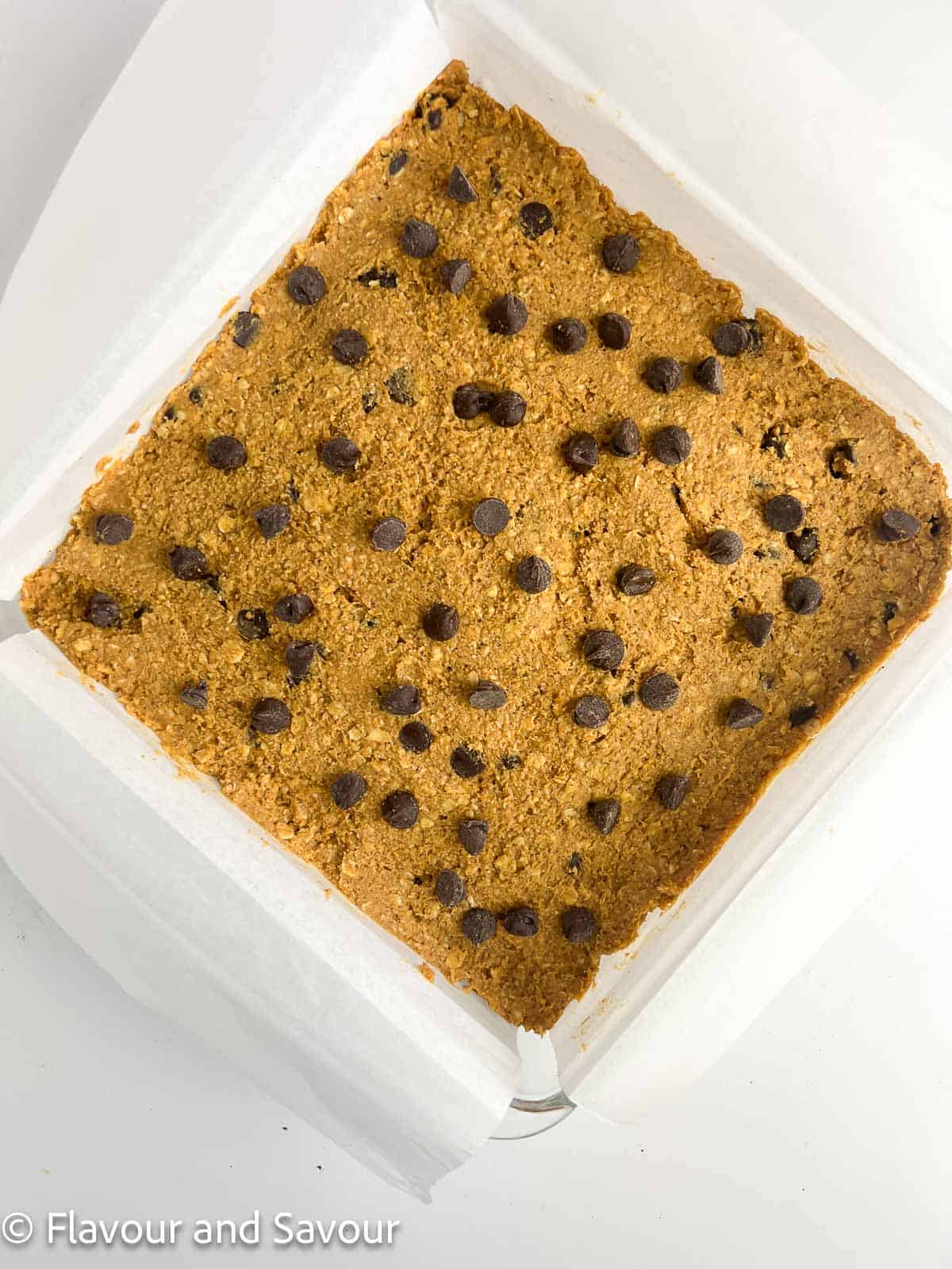 Pumpkin oat bar batter spread in an 8-inch square baking pan.