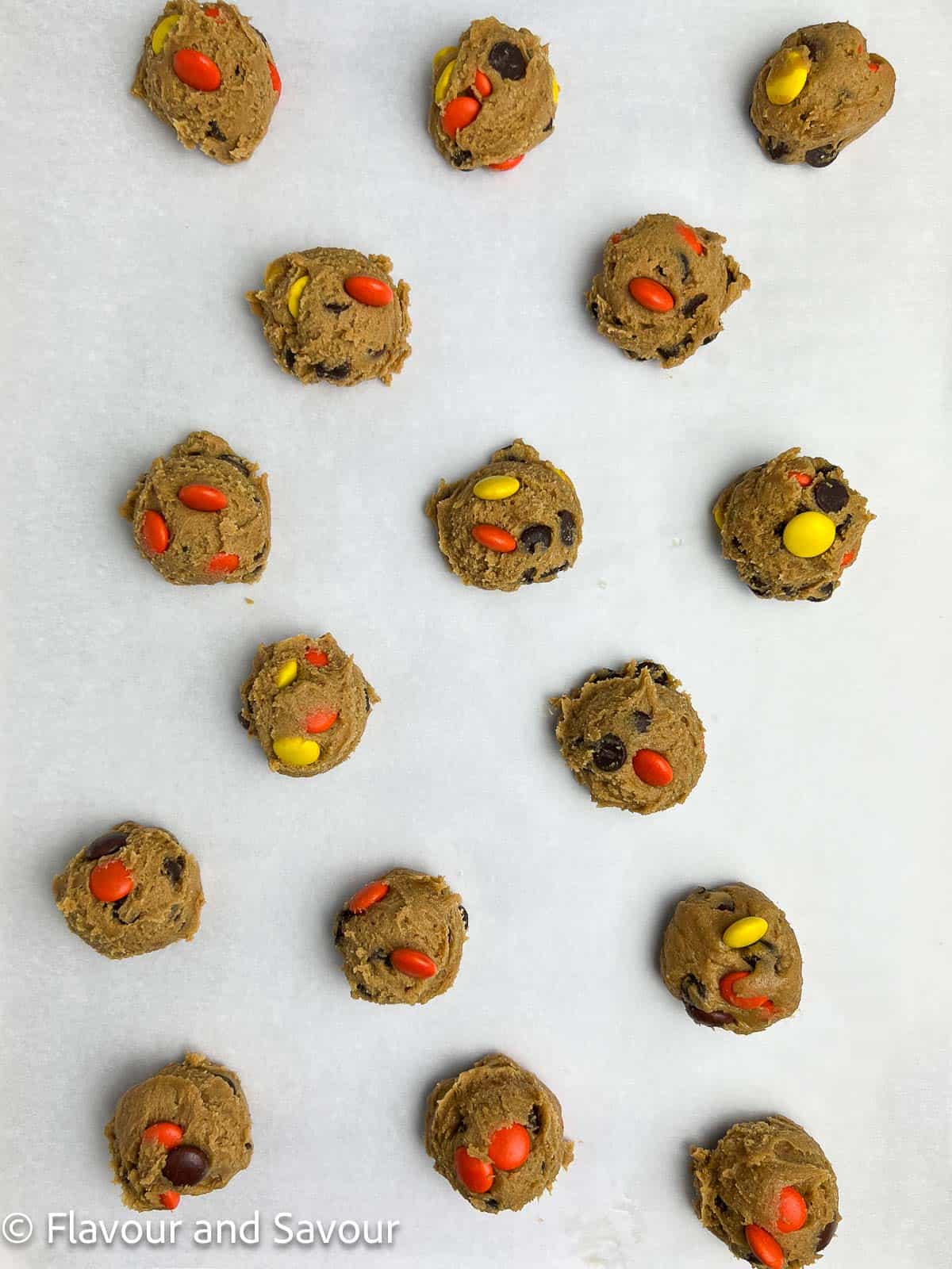 Gluten-free Reese's Pieces Halloween Cookie dough balls on a baking sheet.