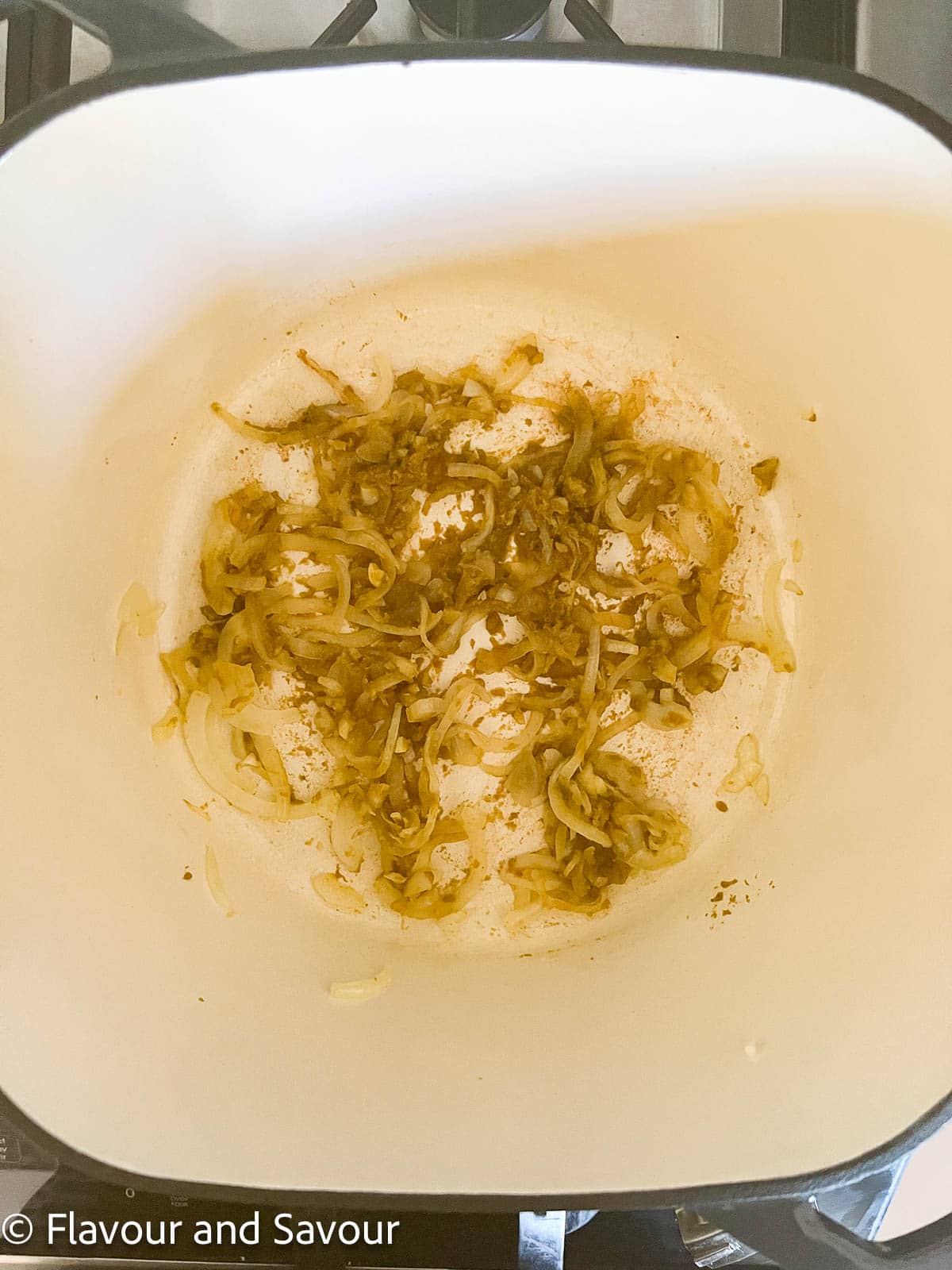 Step 1 to make Thai chicken noodle soup: sauté onions, garlic and green curry paste.