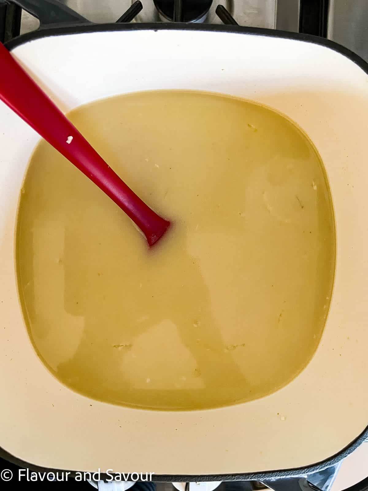 Step 2 to make Thai Chicken Noodle Soup: add broth, coconut milk and fish sauce.